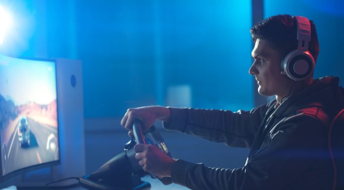 How Progression Systems are Changing Racing Games The guy gamer with headphones playing racing game on his personal computer