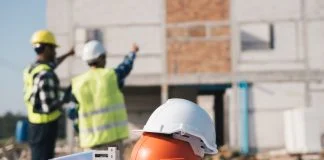 How Sustainable Site Management is Reshaping Modern Real Estate Development Structural engineer and architect working with blueprints discuss at the outdoors construction site.