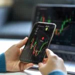 How Evaluation Rules Shape Your Mindset in Futures Prop Trading Successful of trader use phone and laptop prop trading stock exchange graph money