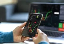 Successful of trader use phone and laptop prop trading stock exchange graph money