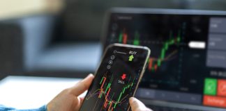 Successful of trader use phone and laptop prop trading stock exchange graph money