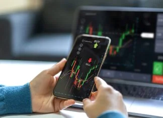 Successful of trader use phone and laptop prop trading stock exchange graph money