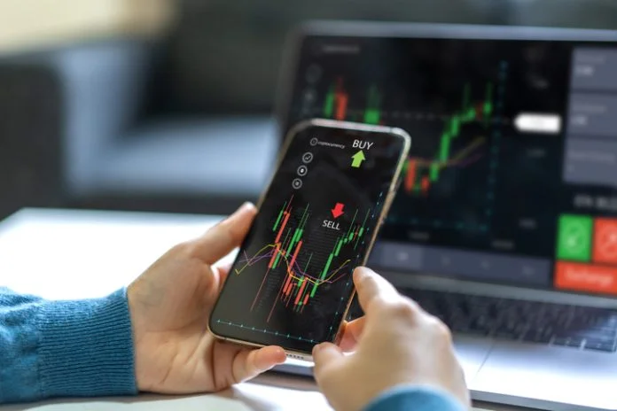 Successful of trader use phone and laptop prop trading stock exchange graph money