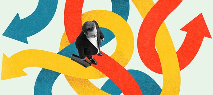 Businessman standing on many tangled multicolored arrows, symbolizing complexity to find right direction in business. Contemporary art collage. The Psychology of Connection and Connectedness