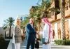 Business Setup in Saudi Arabia: The Complete Guide for Foreign Investors Mature Arabic businessman shaking hands with Caucasian partners in Jeddah Culture, Saudi Arabia Square featuring traditional architecture and palm trees.