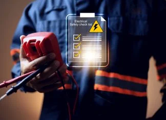 electrical safety concept with electric staff holding multimeter to check power source before start working on machine system or construction site