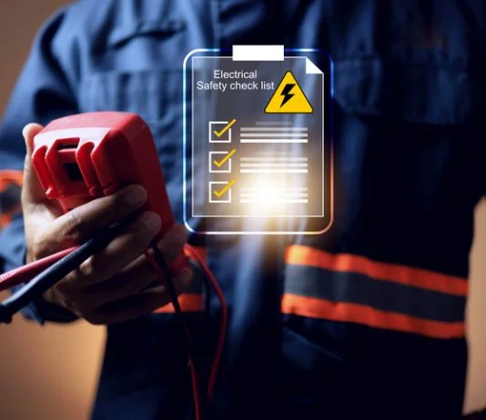 electrical safety concept with electric staff holding multimeter to check power source before start working on machine system or construction site