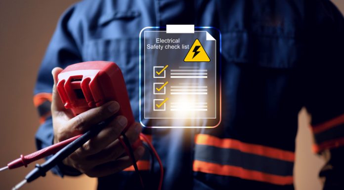Why Electrical Safety Should Be a Business Priority electrical safety concept with electric staff holding multimeter to check power source before start working on machine system or construction site