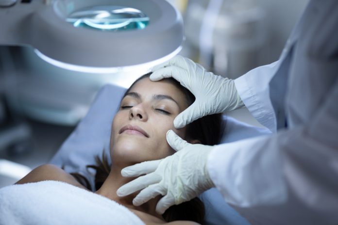 Surgeon examining patient during plastic surgery facial aesthetics Ireland