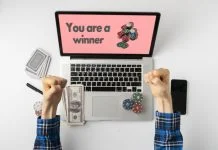 Overhead person playing the gamble games online at home and win the money, the stack of chips on the gadget screen