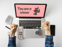 Overhead person playing the gamble games online at home and win the money, the stack of chips on the gadget screen