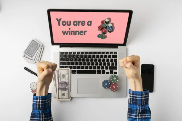 overhead person playing the gamble games online at home and win the money, the stack of chips on the gadget screen Overhead person playing the gamble games online at home and win the money, the stack of chips on the gadget screen