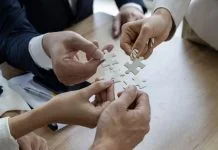 Rhett Buttle: The Coalition Builder Behind Policy Wins for Small Business Business people work together to solve a jigsaw puzzle, representing the importance of teamwork and collaboration and business coalition