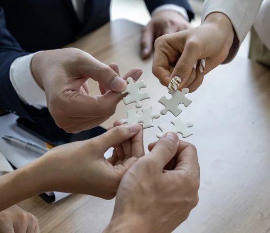 Rhett Buttle: The Coalition Builder Behind Policy Wins for Small Business Business people work together to solve a jigsaw puzzle, representing the importance of teamwork and collaboration and business coalition