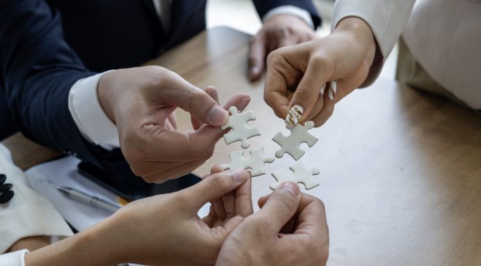 Rhett Buttle: The Coalition Builder Behind Policy Wins for Small Business Business people work together to solve a jigsaw puzzle, representing the importance of teamwork and collaboration and business coalition
