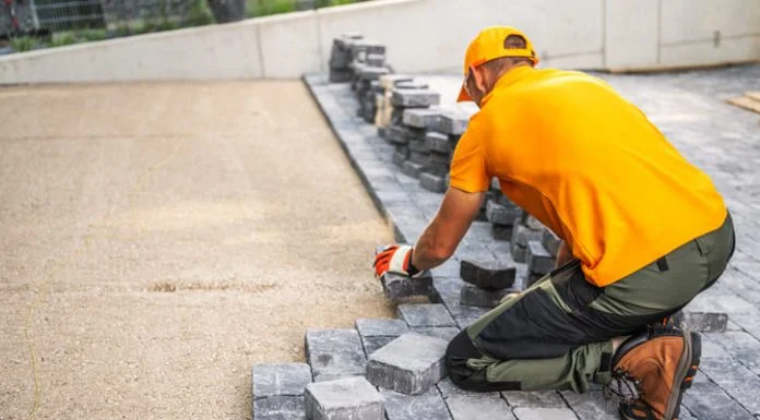 Starting a Patio Paving Contracting Business in the EU Worker Laying Cobblestones for a Patio in a Residential Backyard on a Sunny Day
