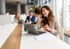 marketing channel through phone calls. Woman talking over smart phone while sitting with laptop