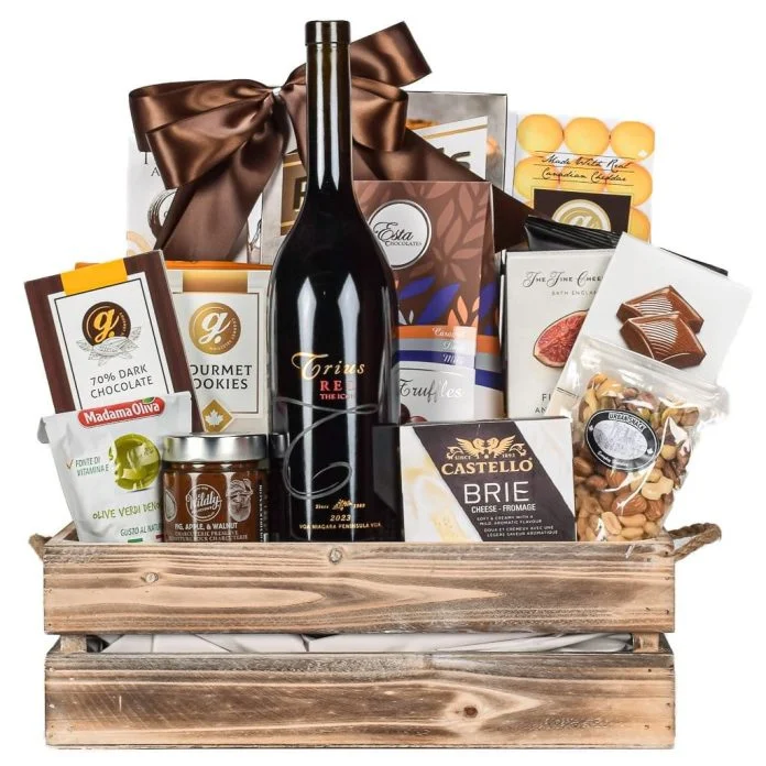 Corporate gift basket with red wine, gourmet chocolates, brie cheese, and mixed nuts in a wooden crate