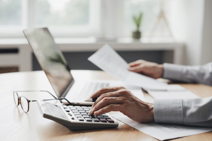 Businessman accountant, financial advisor or banker making calculations Credit Builders That Help You Build Emergency Savings
