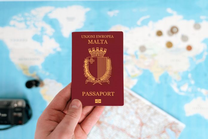 Malta Passport holding in hand with map Malta Passport holding in hand with map