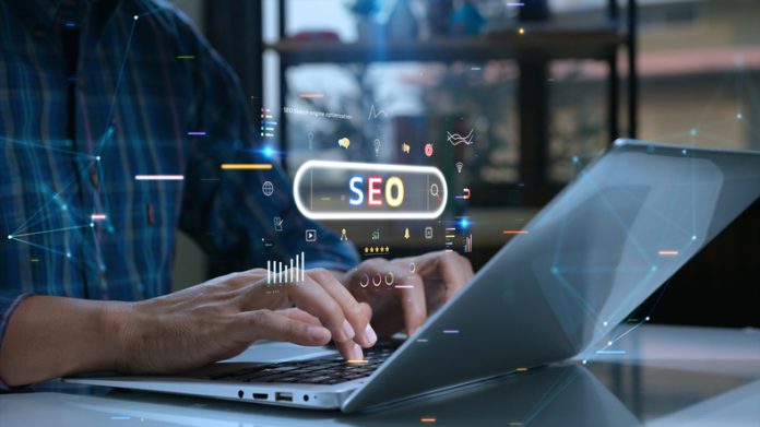 Person uses a laptop with various digital SEO icons and graphs overlaid, symbolizing online marketing and search engine optimization. SEO