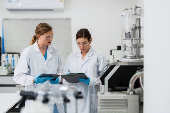 Female scientists analyzing data on digital tablet and clipboard in pharmaceutical laboratory. Hydrostatic Pressure Testing Equipment in the USA