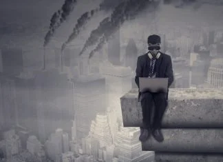 Most Companies Aren’t Built to Care About Impact Male worker working on the rooftop while using laptop computer and wear a gas mask with air pollution in the city, Companies operating despite the negative impact on society concept.