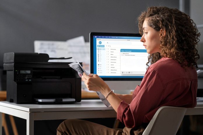 medium-shot-woman-sitting-desk_compressed (1) Mailing Programs in business