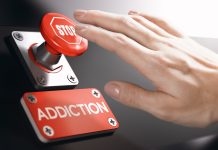 Why Addiction Recovery is Becoming Big Business in the Tech Space Woman pressing a panic button with stop sign to overcome addiction or dependence problems.