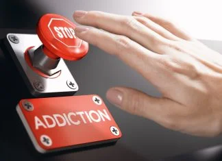 Why Addiction Recovery is Becoming Big Business in the Tech Space Woman pressing a panic button with stop sign to overcome addiction or dependence problems.