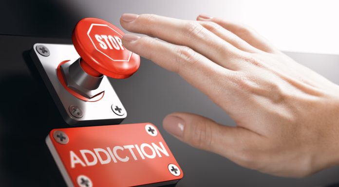 Why Addiction Recovery is Becoming Big Business in the Tech Space Woman pressing a panic button with stop sign to overcome addiction or dependence problems.