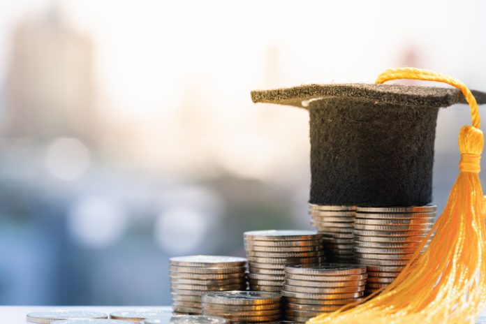 Graduation hat on top coin stack. Saving money for increase investment to student loan, education scholarship money