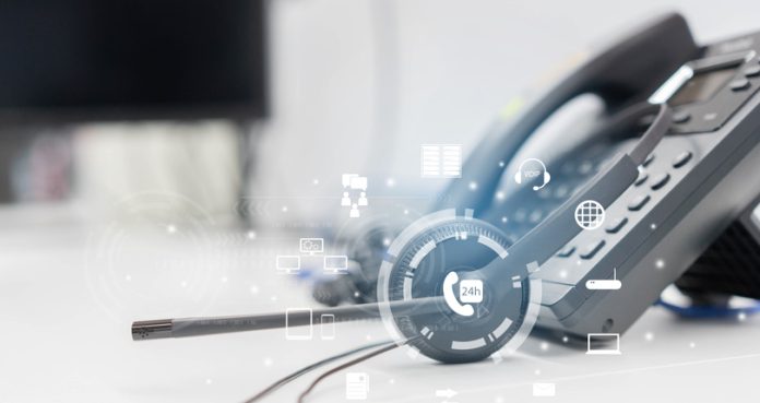close up headset of call center and VOIP communication with futuristic virtual icon telecommunication technology on office table in monitoring room for network operation job concept outbound operation