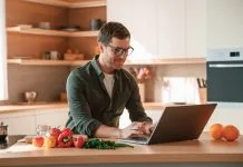 Businessman cooking in the kitchen while working. Cooking and nutrition leadership concept