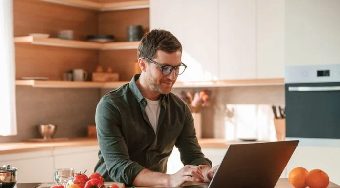 Businessman cooking in the kitchen while working. Cooking and nutrition leadership concept