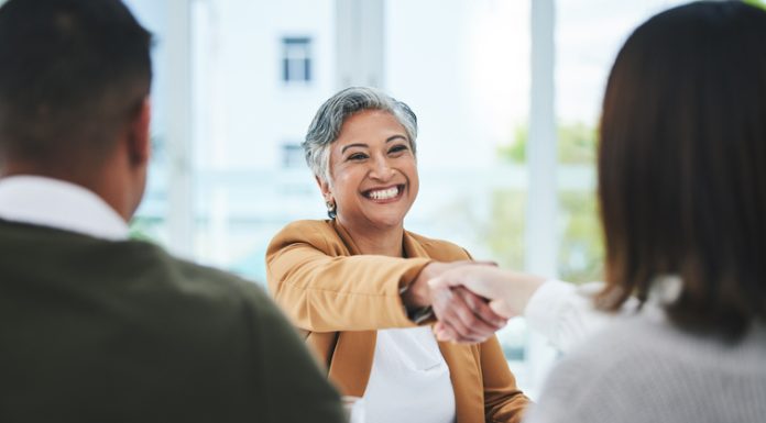 The Dog-Eat-Dog World of ‘Work Perks’ Handshake, job interview or business people with a happy mature woman for partnership in office. smile or business people shaking hands for success, work perks, promotion or negotiation in meeting