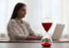 Woman using laptop indoors, selective focus for time management