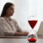 Woman using laptop indoors, selective focus for time management