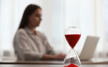 Woman using laptop indoors, selective focus for time management