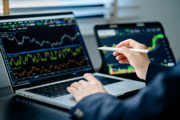 Investor analyze and valuation the stock market index digital tablet screen to trade the stock chart for planning investment take profit, trade stock exchange market and cryptocurrency data, financial trading habits