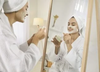 Smiling girl after shower do morning beauty face procedures, take care of skin. Skincare and cosmetology concept.