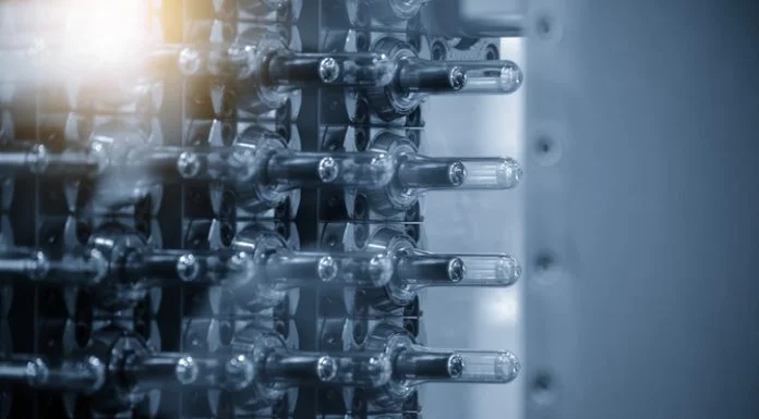 Close up scene of injection process group of preform shape of PET bottle products in the blue scene.