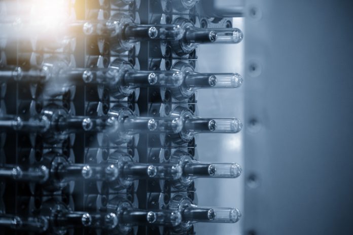 Close up scene of injection process group of preform shape of PET bottle products in the blue scene Close up scene of injection process group of preform shape of PET bottle products in the blue scene.