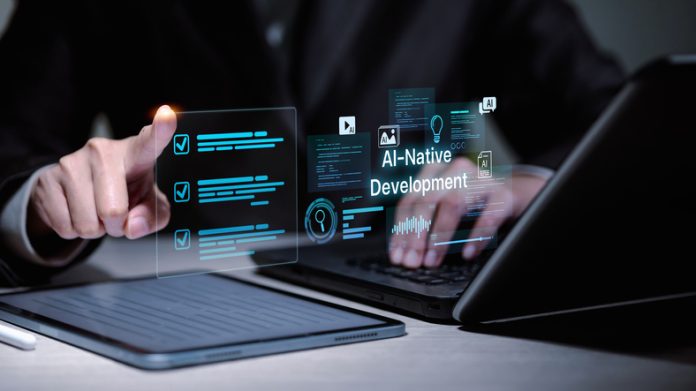 Developer working on AI-Native Development with laptop and digital tablet interface. Software developer using laptop and tablet for AI-native development.