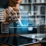 Business professional reviewing and signing a digital contract on a laptop with electronic document workflow interface, representing e-signature, approval process, compliance,and paperless management.