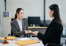 The Dog-Eat-Dog World of ‘Work Perks’ Asian lawyer and client shaking hands after signing a business contract in a modern office, symbolizing trust, legal agreement, partnership, and corporate success. Workplace Perks concept