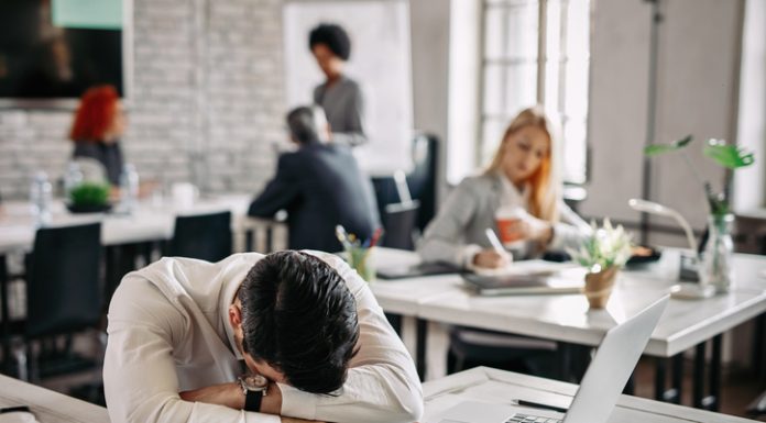 The Business Case for Fixing Presenteeism: Soft Skills, Hard Returns Presenteeism - Overworked businessman taking a break from work and napping on his desk.