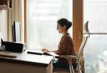 Happy successful millennial indian ethnic business lady working in modern home office, using computer software applications, Ergonomics, creating new internet project, communicating distantly with client.