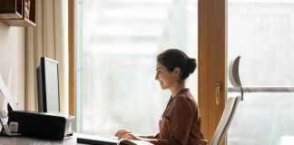 Why Better Ergonomics is One of the Smartest Business Investments Happy successful millennial indian ethnic business lady working in modern home office, using computer software applications, Ergonomics, creating new internet project, communicating distantly with client.
