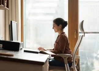 Happy successful millennial indian ethnic business lady working in modern home office, using computer software applications, Ergonomics, creating new internet project, communicating distantly with client.